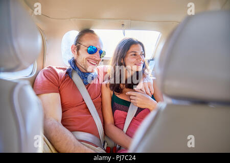Affectionate couple riding in back seat of car Stock Photo