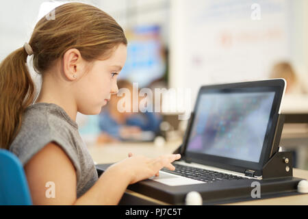 Girl playing game on laptop Stock Photo