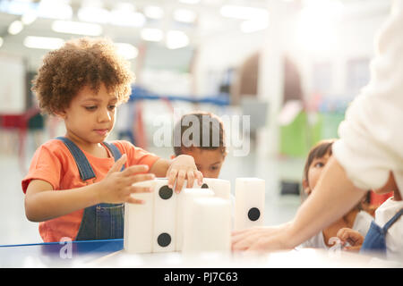 Curious kids playing with large dominos in science center Stock Photo