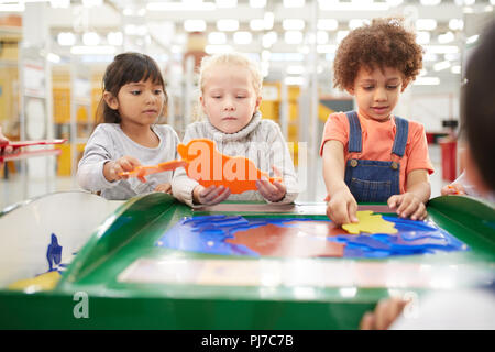 Kids playing at interactive exhibit in science center Stock Photo
