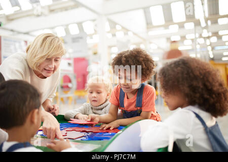 Teacher and students playing at interactive exhibit in science center Stock Photo