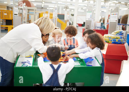 Teacher and students playing at interactive exhibit in science center Stock Photo