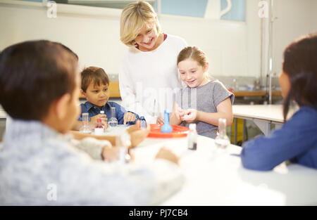 Teacher and students enjoying elephants toothpaste foam interactive exhibit in science center Stock Photo