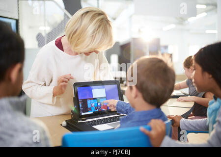 Teacher and students using laptop in science center Stock Photo