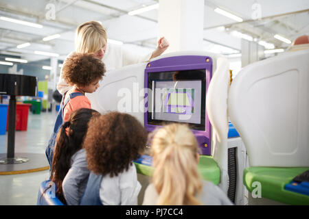 Teacher and students at interactive exhibit in science center Stock Photo