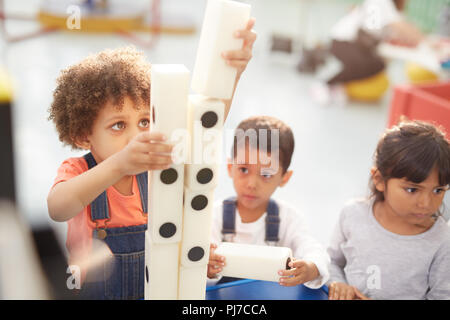 Curious kids stacking large dominos at interactive exhibit in science center Stock Photo