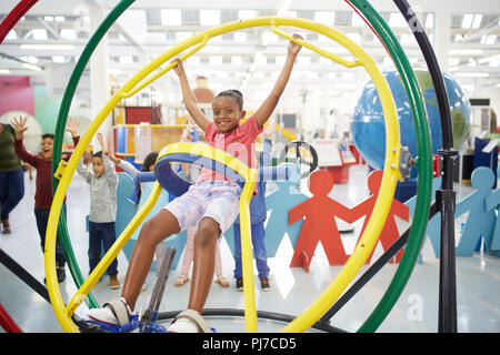 Portrait playful girl using gyroscope in science center Stock Photo