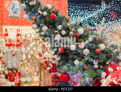 Shopping centre background: decorated Christmas tree with silver and red bauble, blurred Christmas toys on the background Stock Photo