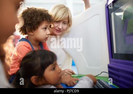 Curious kids using computer in science center Stock Photo