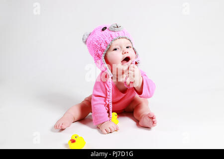 The little child crawls behind the ducks Stock Photo