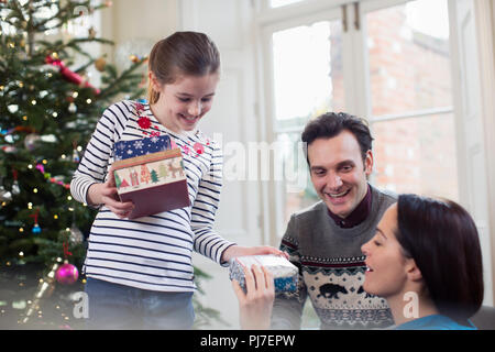 Family opening Christmas gifts in living room Stock Photo