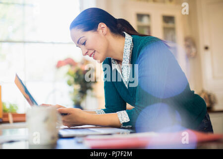 Woman using laptop in kitchen Stock Photo