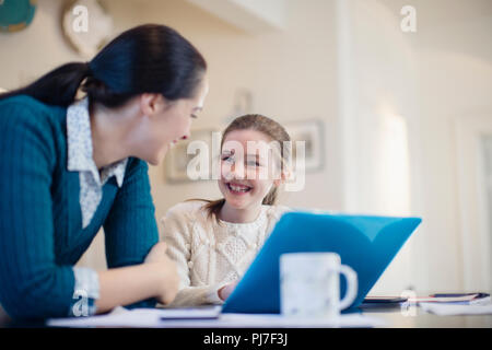 Mother and daughter smiling confident studying and working at home ...