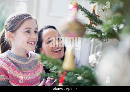 Happy mother and daughter decorating Christmas tree Stock Photo