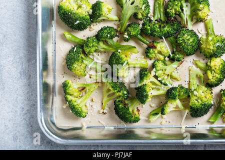 Roasted broccoli florets with cheese on a baking tray Stock Photo
