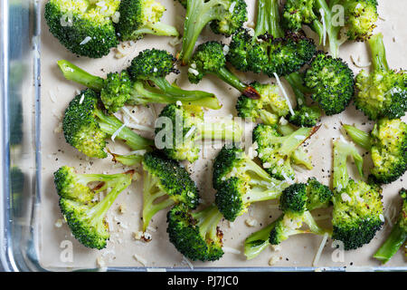 Roasted broccoli florets with cheese on a baking tray Stock Photo