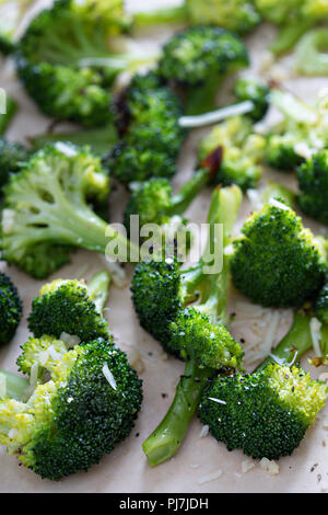 Roasted broccoli florets with cheese on a baking tray Stock Photo