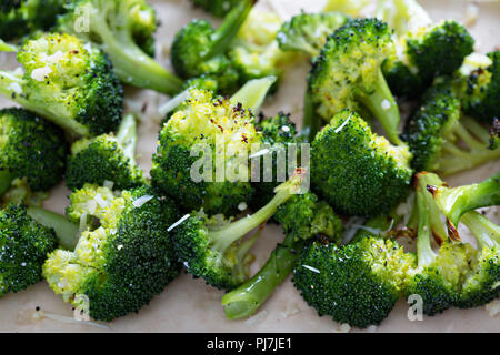 Roasted broccoli florets with cheese on a baking tray Stock Photo