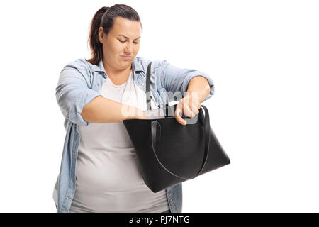 Overweight female searching for something in her handbag isolated on white background Stock Photo