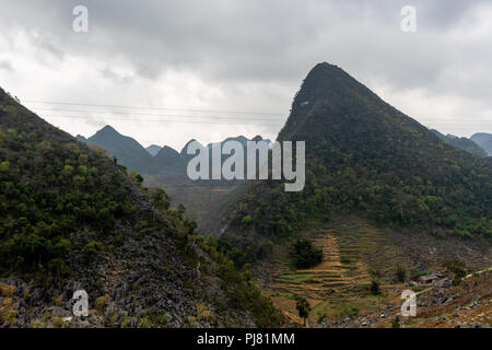 Ha Giang, Vietnam - March 18, 2018: Mountains and terraced fields surrounded by clouds in northern Vietnam Stock Photo