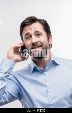 Caring dark-haired husband calling his lovely wife during break at work Stock Photo