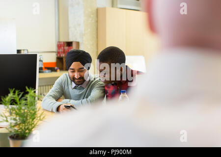 Businessmen using smart phone in office Stock Photo