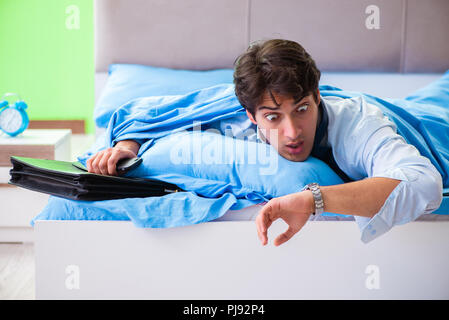 Employee in the bedroom being late for his job Stock Photo