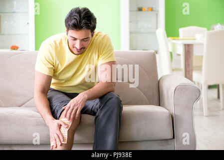 Man applying pepper Capsicum plaster to relieve pain Stock Photo