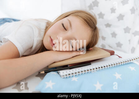 Tired teenager sleeping on her copybooks Stock Photo
