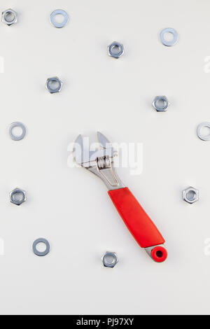 Creative Flat lay of metal nuts and spanner on white background. Repair or improvement top view concept pattern. Stock Photo