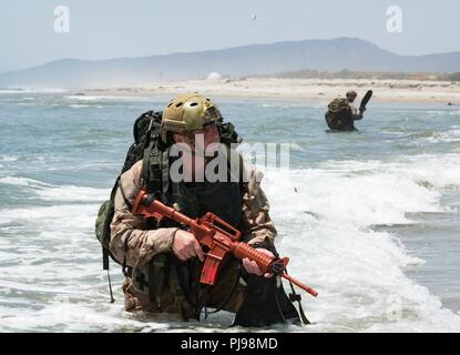 Canadian Army Master Corporal Paul Tremblay, a member of the Canadian 2nd Battalion Royal 22e Régiment (22nd Regiment) Reconnaissance team secures the beach amphibious landing training on rigid hull inflatable boats at Blue Beach training area during the biennial Rim of the Pacific (RIMPAC) Exercise at Marine Corps Base Pendleton, California, July 8, 2018. Twenty-five nations, 46 ships, five submarines, about 200 aircraft, and 25,000 personnel are participating in RIMPAC from June 27 to Aug. 2 in and around the Hawaiian Islands and Southern California. The world’s largest international maritim Stock Photo