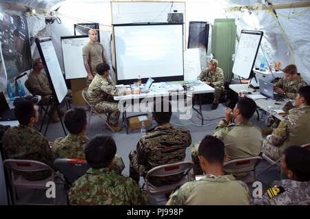 JOINT BASE PEARL HARBOR-HICKAM, Hawaii (July 2, 2018) - A Soldier from the U.S. Army's 1st Battalion, 1st Special Forces Group (ABN) conducts an intelligence brief as multinational SOF teams prepare for a raid during RIMPAC 2018. Twenty-five nations, more than 45 ships and submarines, about 200 aircraft, and 25,000 personnel are participating in RIMPAC from June 27 to Aug. 2 in and around the Hawaiian Islands and Southern California. The world's largest international maritime exercise, RIMPAC provides a unique training opportunity while fostering and sustaining cooperative relationships among  Stock Photo