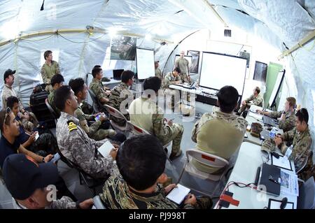 JOINT BASE PEARL HARBOR-HICKAM, Hawaii (July 02, 2018) - A Soldier from the U.S. Army's 1st Battalion, 1st Special Forces Group (ABN) conducts an intelligence brief as multinational SOF teams prepare for a raid during RIMPAC 2018. Twenty-five nations, more than 45 ships and submarines, about 200 aircraft, and 25,000 personnel are participating in RIMPAC from June 27 to Aug. 2 in and around the Hawaiian Islands and Southern California. The world's largest international maritime exercise, RIMPAC provides a unique training opportunity while fostering and sustaining cooperative relationships among Stock Photo