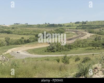 U.S. Army Soldiers assigned to the 961st Engineer Company and Romanian Land Forces engineers assigned to the 10th Engineer Battalion conduct drainage improvements on an existing road as part of a construction project in support of Resolute Castle 2018 at the Joint National Training Center, Cincu, Romania, July 6, 2018. The 961st EN Co., Ada, Ohio, are currently concentrating on the first and second sections of the three sectioned 2-kilometers-long curvy, gravel road, during the fourth engineer rotation of RC18. Stock Photo