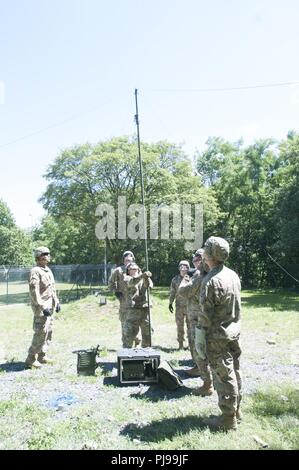 U.S. Army Staff Sgt. David Nelson, a signal support systems specialist assigned to 218th MEB in support of Resolute Castle 2018, teaches members of Company B, 151st Expeditionary Signal Battalion how to set up a modified FM antenna for a Harris 1944 broad band antenna during a high frequency radio class taught by Nelson. The 218th MEB, Forward, and Co. B, 151st ESC, both units are members of the South Carolina Army National Guard and deployed to Poland in support of Atlantic Resolve. Stock Photo