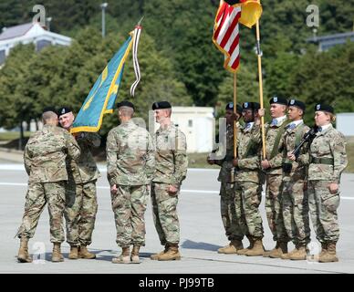 Brig. Gen. Christopher C. LaNeve, 7th Army Training Command's commander, passes the guidon representing the Joint Multinational Readiness Center to the incoming commander, Col. Joseph E. Hilbert, at JMRC's change of command ceremony at the Hohenfels Training Area, Hohenfels, Germany, July 10, 2018. The change of command ceremony is a tradition that represents a formal transfer of authority and responsibility from the outgoing commander to the incoming commander. Stock Photo