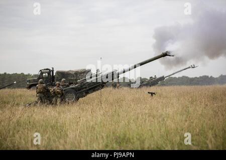 U.S. Marines with Echo Battery, 2nd Battalion, 10th Marine Regiment (2/10), 2nd Marine Division, fire an M777 Howitzer at Salisbury, England, July 2, 2018. Marines with the unit conducted live-fire exercises using the M777 Howitzer during exercise Green Cannon 18. Green Cannon is a multinational training exercise providing U.S. Marines the opportunity to exchange tactics and techniques as well as project lethality and combat power across the globe alongside partner nations. Stock Photo