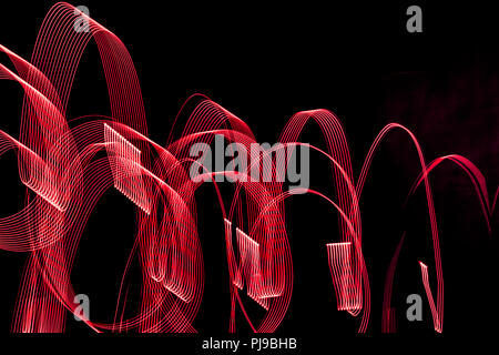 Bright red spiral patterns from light strips on a black background Stock Photo