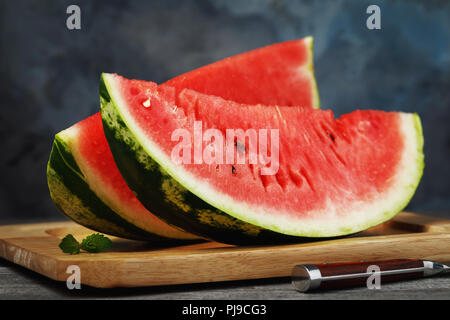 Two ripe watermelon slices on a wooden table, close-up Stock Photo