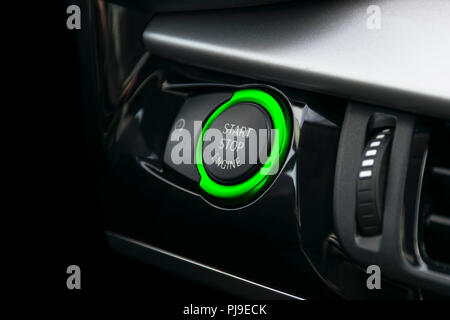 Car dashboard with focus on green engine start stop button. Car interior details. Car detailing Stock Photo