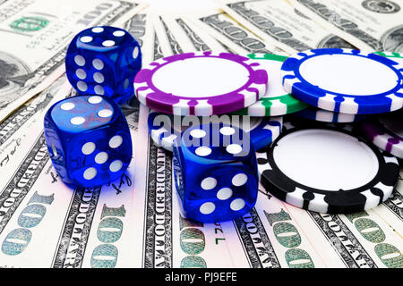 Stack of Poker chips with blue dice rolls on a dollar bills, Money. Poker table at the casino. Poker game concept. Playing a game with dice. Casino di Stock Photo