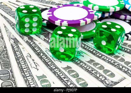 Stack of Poker chips with green dice rolls on a dollar bills, Money. Poker table at the casino. Poker game concept. Playing a game with dice. Casino d Stock Photo