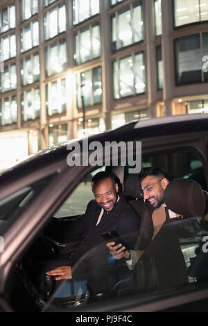 Businessman showing smart phone to driver in crowdsourced taxi Stock Photo