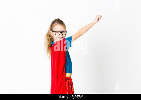 blond supergirl with glasses and red robe und blue shirt is posing in the studio Stock Photo