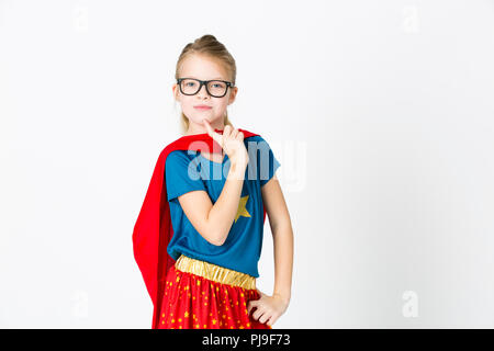 blond supergirl with glasses and red robe und blue shirt is posing in the studio Stock Photo