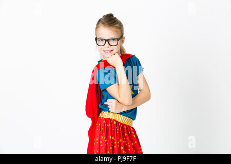 blond supergirl with glasses and red robe und blue shirt is posing in the studio Stock Photo