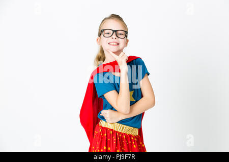 blond supergirl with glasses and red robe und blue shirt is posing in the studio Stock Photo