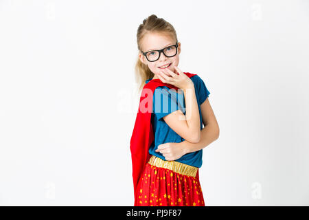 blond supergirl with glasses and red robe und blue shirt is posing in the studio Stock Photo