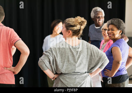 Smiling active seniors exercising in circle Stock Photo