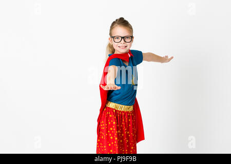 blond supergirl with glasses and red robe und blue shirt is posing in the studio Stock Photo